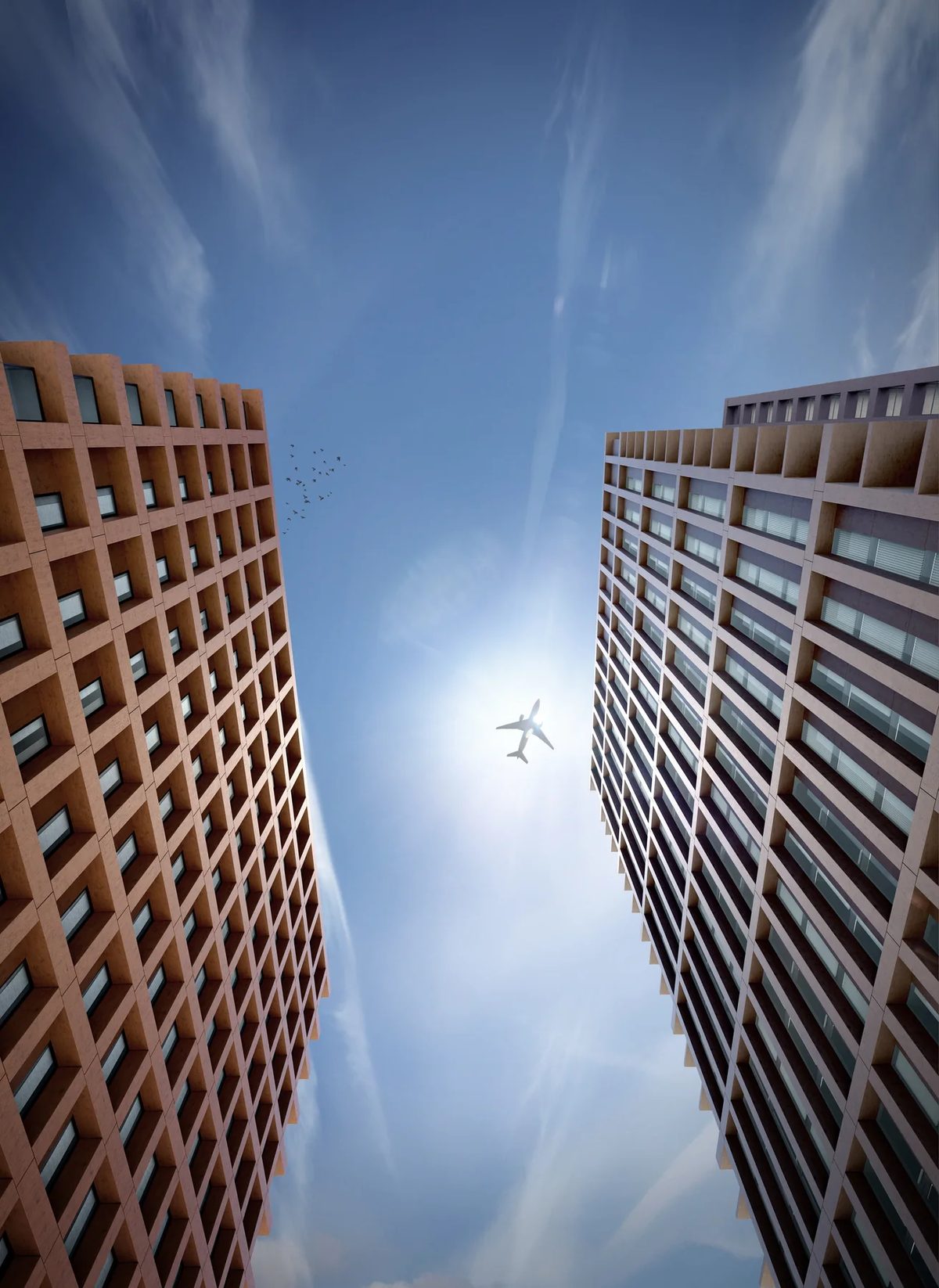 Upward view between Abu Dhabi co-living towers showing warm lattice facades and open sky