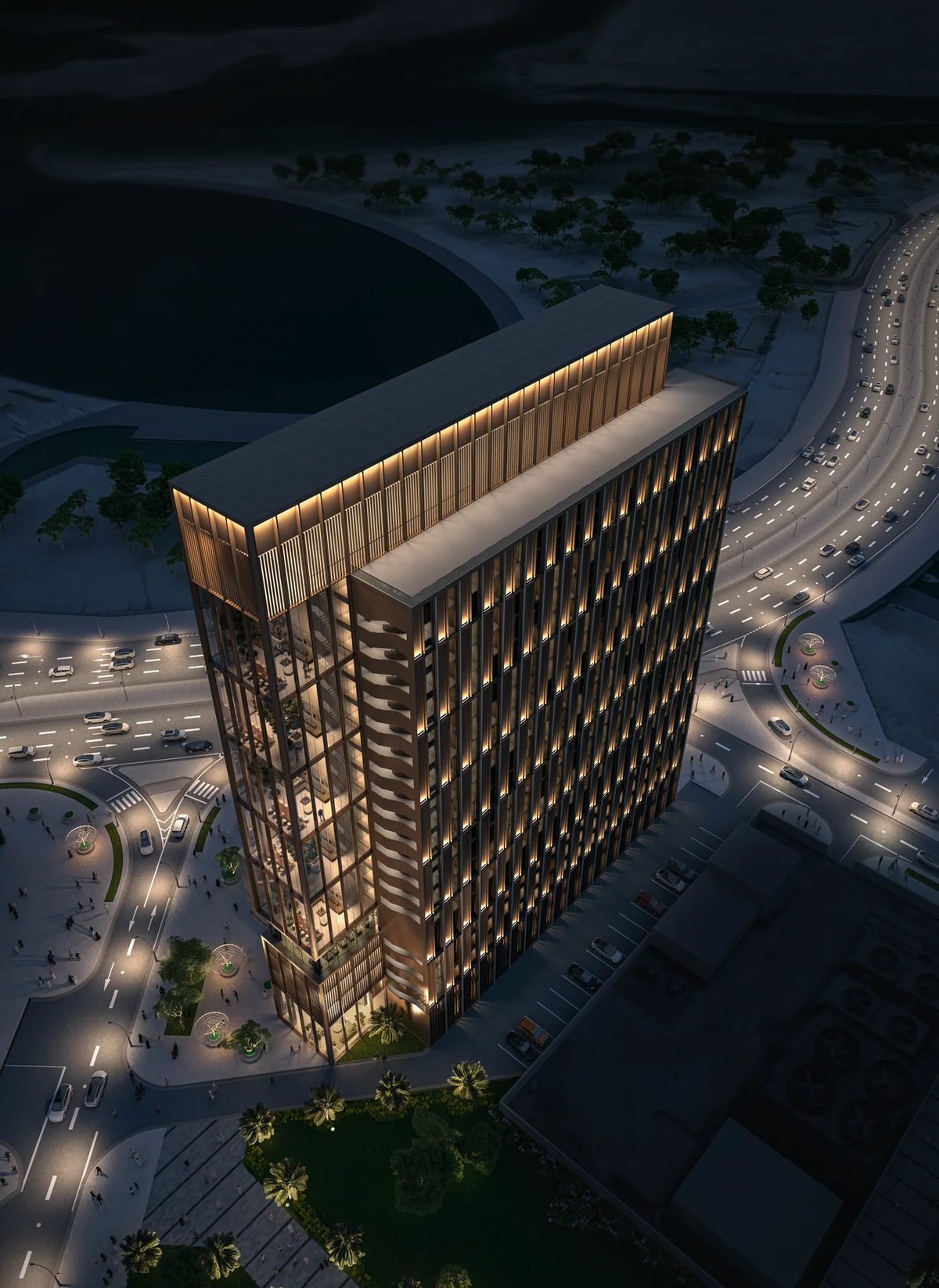 Aerial night view of Abu Dhabi co-living tower, waterfront roads, and lit landscape paths