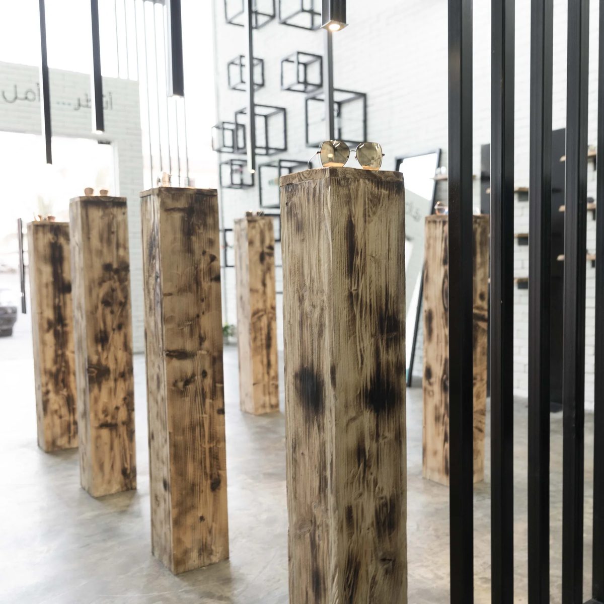 Freestanding timber display plinths arranged between black steel frames in Jamjom retail prototype